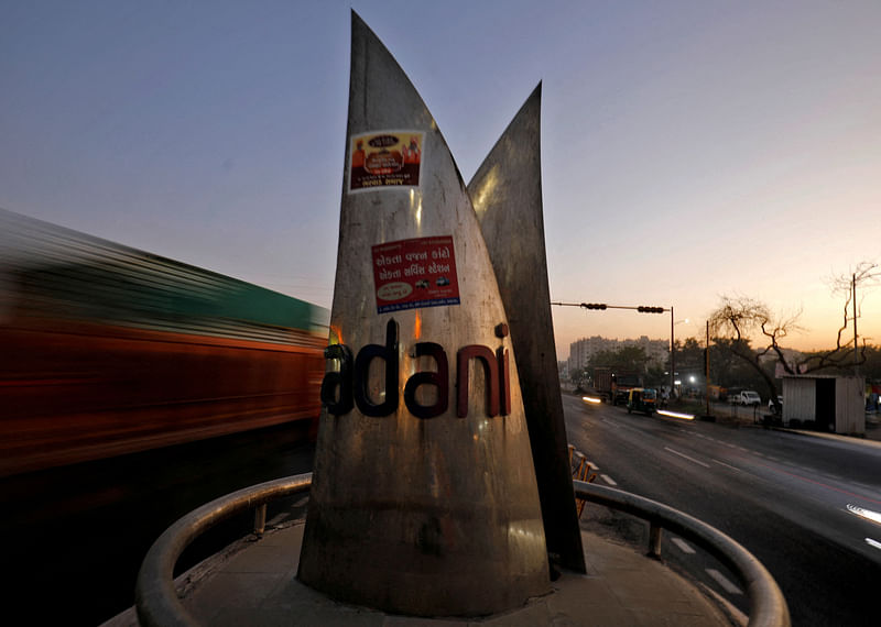 Traffic moves past the logo of the Adani Group installed at a roundabout on the ring road in Ahmedabad, India, on 2 February,  2023.