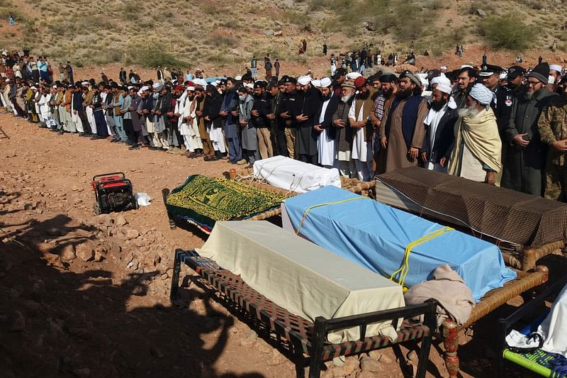 In this picture taken on 30 January, 2023, relatives and local residents offer funeral prayers for students who drowned after a boat capsized in Tanda Dam, in Kohat district of northern Khyber Pakhtunkhwa province