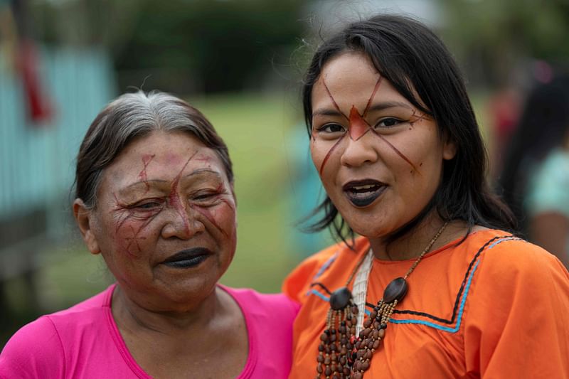 Siekopai indigenous Milena Piaguaje (R) and her grandmother, both with traditional paint designs on their faces, pose for a picture during the second binational meeting of the Siekopai Nation community in the Amazon region in Lagartococha, Peru, on 10 January, 2023