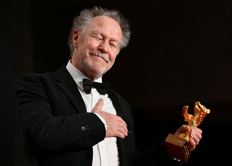 Director Nicolas Philibert reacts as he poses with the Golden Bear for Best Film Award for "On the Adamant" during a news conference at the 73rd Berlinale International Film Festival in Berlin, Germany, 25 February, 2023.