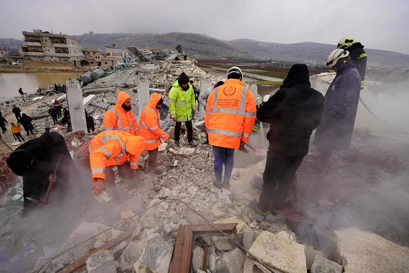 White Helmet rescue workers search for victims and survivors in the rubble of collapsed buildings, following an earthquake in the town of Sarmada in the countryside of the northwestern Syrian Idlib province, early on 6 February 2023.