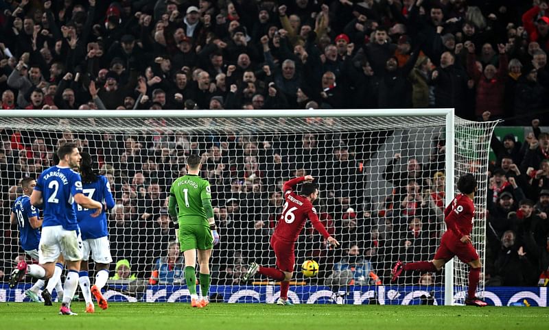 Liverpool's Egyptian striker Mohamed Salah (R) celebrates scoring the opening goal during the English Premier League football match between Liverpool and Everton at Anfield in Liverpool, north west England on February 13, 2023