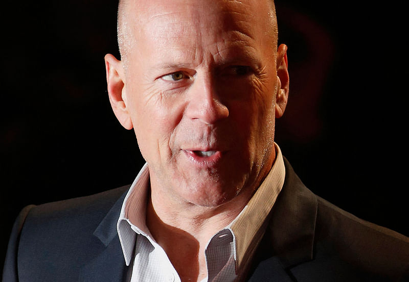 In this file photo taken on 7 February, 2013 US actor Bruce Willis poses for photographers while arriving for the UK premiere of 'A Good Day To Die Hard', the fifth film in the Die Hard franchise, in central London.