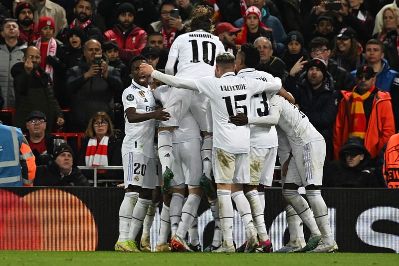 Real Madrid's French forward Karim Benzema is mobbed by teammates after scoring the team's third goal during the UEFA Champions League last 16 first leg football match between Liverpool and Real Madrid at Anfield in Liverpool, north west England on 21 February, 2023