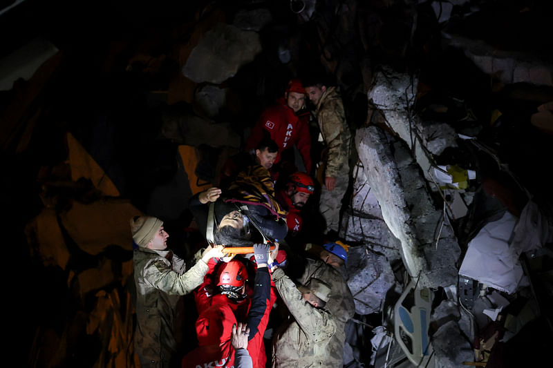 Muhammet Ruzgar, 5, is carried out by rescuers from the site of a damaged building, following an earthquake in Hatay, Turkey, 7 February 2023.