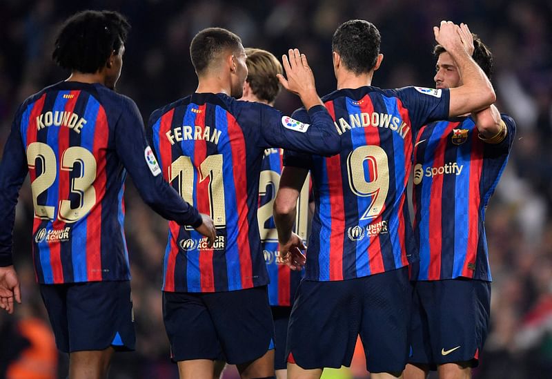 Barcelona's Spanish midfielder Sergi Roberto (R) celebrates scoring the opening goal during the Spanish League football match between FC Barcelona and Cadiz CF at the Camp Nou stadium in Barcelona, on 19 February, 2023