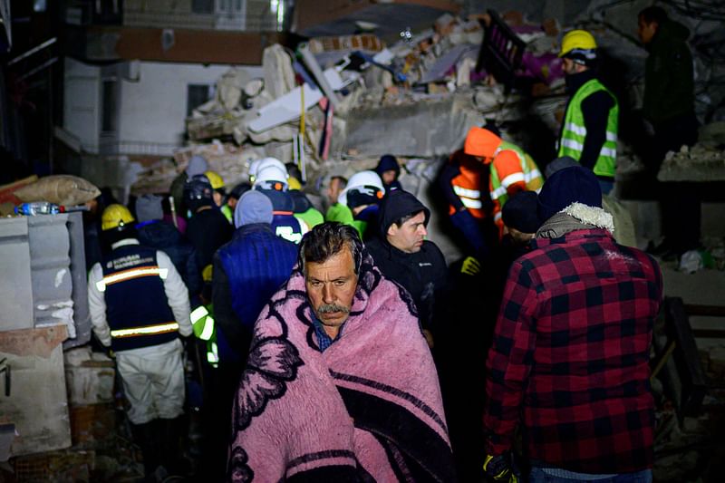 A local resident walks among the rubble of a collapsed building in Hatay, early on 10 February, 2023, after the 7.8 magnitude earthquake that killed over 11.200 people. Searchers were still pulling survivors on 8 February from the rubble of the earthquake that killed over 11,200 people in Turkey and Syria, even as the window for rescues narrowed. For two days and nights since the 7.8 magnitude quake, thousands of searchers have worked in freezing temperatures to find those still alive under flattened buildings on either side of the border.