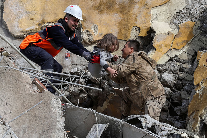 Muhammet Ruzgar, 5, is carried out by rescuers from the site of a damaged building, following an earthquake in Hatay, Turkey, 7 February 2023.