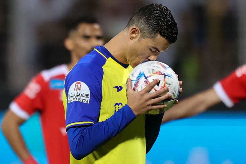 Al-Nassr's forward Cristiano Ronaldo kisses the ball before taking a penalty during the Saudi Pro League match between Al-Wehda and Al-Nassr at the King Abdulaziz Stadium in Mecca on 9 February, 2023