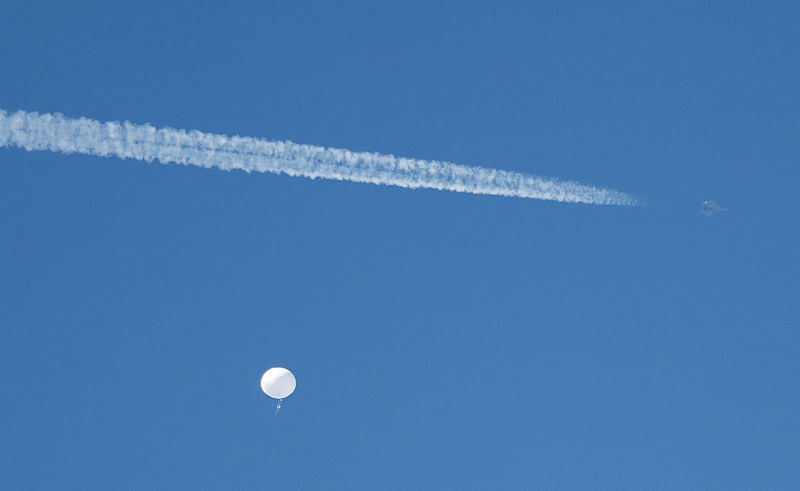 A jet flies by a suspected Chinese spy balloon as it floats off the coast in Surfside Beach, South Carolina, U.S. February 4, 2023