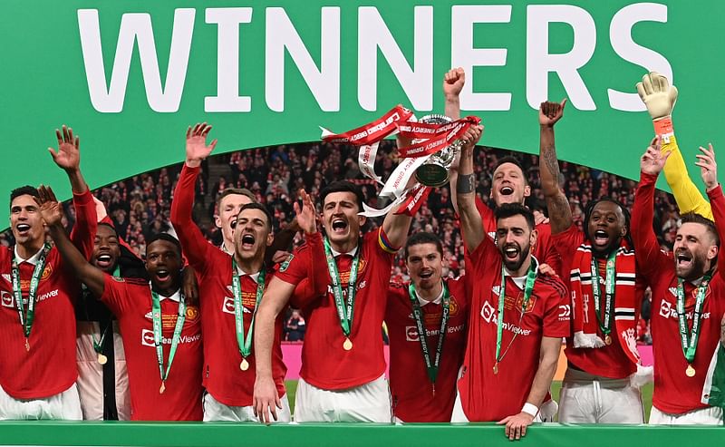 Manchester United's Portuguese midfielder Bruno Fernandes (3R) and Manchester United's English defender Harry Maguire (C) celebrate with the trophy after their victory in the English League Cup final football match between Manchester United and Newcastle United at Wembley Stadium, north-west London on 26 February, 2023