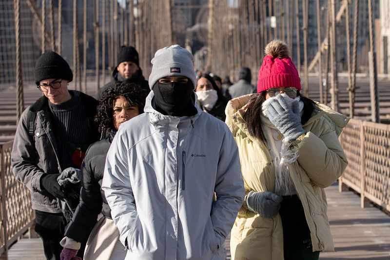 People walk during cold temperature and high winds in Manhattan, as deep cold spread across the northeast United States in New York City, New York, U.S., February 4, 2023