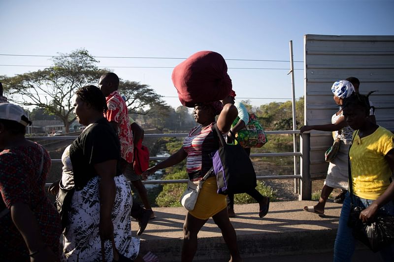 Haitians cross the border between Quanamienthe in Haiti and Dajabon in the Dominican Republic to work in the binational market to buy or sell products in Dajabon, Haiti, on 20 March 2023.