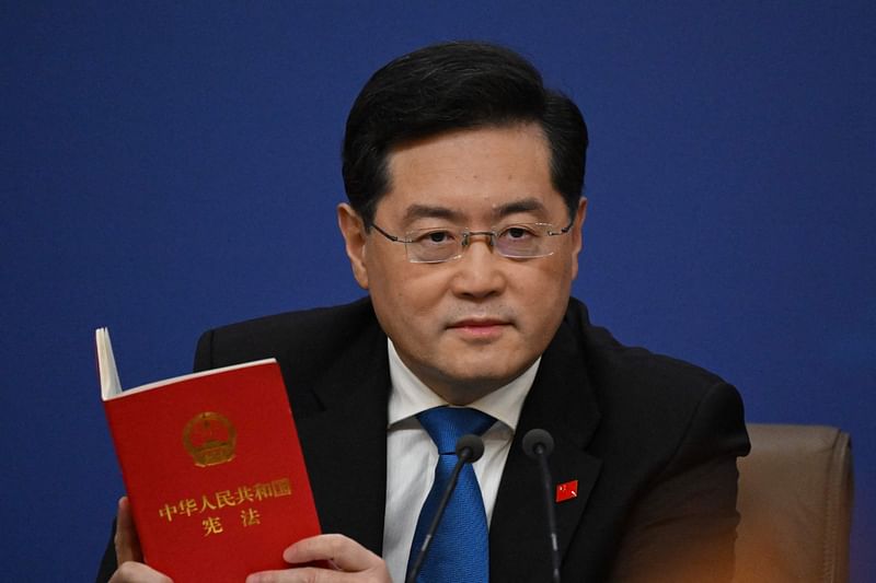 China's Foreign Minister Qin Gang holds a copy of China's constitution during a press conference at the Media Center of the National People's Congress in Beijing on 7 March, 2023