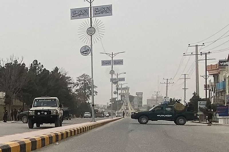 Taliban security personnel (R) block a road in Mazar-i-Sharif on 9 March, 2023, following a blast at the office of Taliban governor of Afghanistan’s Balkh province