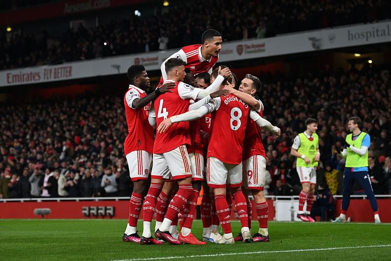 Arsenal's Norwegian midfielder Martin Odegaard is mobbed by teammates after scoring the team's third goal during the English Premier League football match between Arsenal and Everton at the Emirates Stadium in London on 1 March, 2023