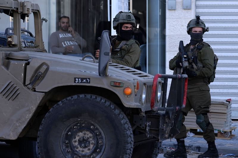 Israeli soldiers stand guard during an operation near the Jit junction west of Nablus in the occupied northern West Bank on 12 March, 2023