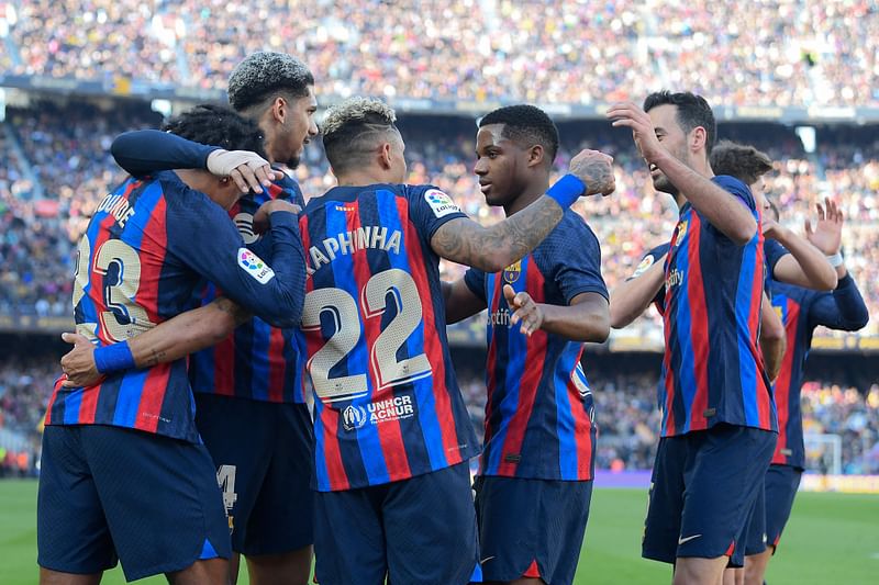 Barcelona's Brazilian forward Raphinha celebrates with teammates scoring his team's first goal during the Spanish League football match between FC Barcelona and Valencia CF at the Camp Nou stadium in Barcelona on 5 March, 2023