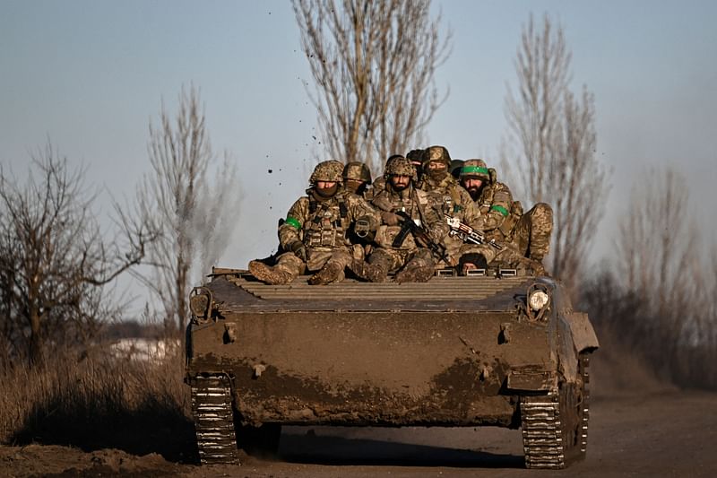 Ukrainian servicemen sit on a BMP military vehicle as they move towards Bakhmut in the region of Donbas, on 13 March, 2023, amid the Russian invasion of Ukraine