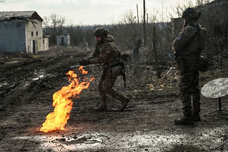 Ukrainian servicemen light a fire with gun powder to get warm near the city of Bakhmut in the region of Donbas on 5 March, 2023, amid the Russian invasion of Ukraine