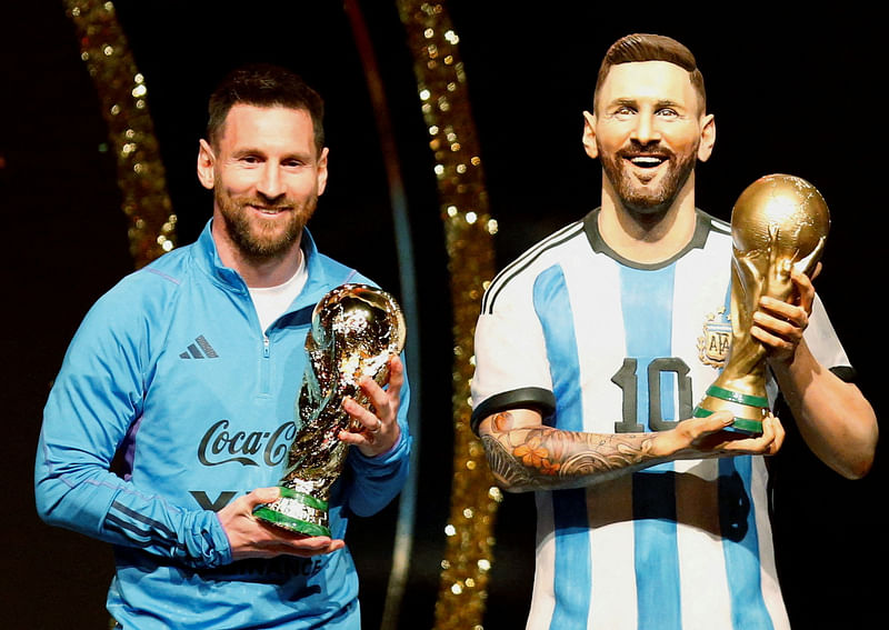 Argentina's Lionel Messi poses with a statue of himself holding the World Cup during a Conmebol event at the Conmebol headquarters in Luque, Paraguay on 27 March 2023