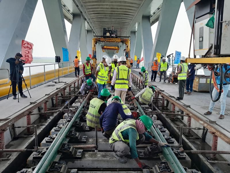 Workers installing a rail track on Padma Bridge