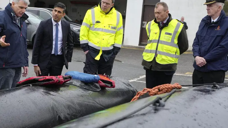 Britain's prime minister Rishi Sunak looks at buoyancy aids and an inflatable rubber dinghy during a visit to the port of Dover.