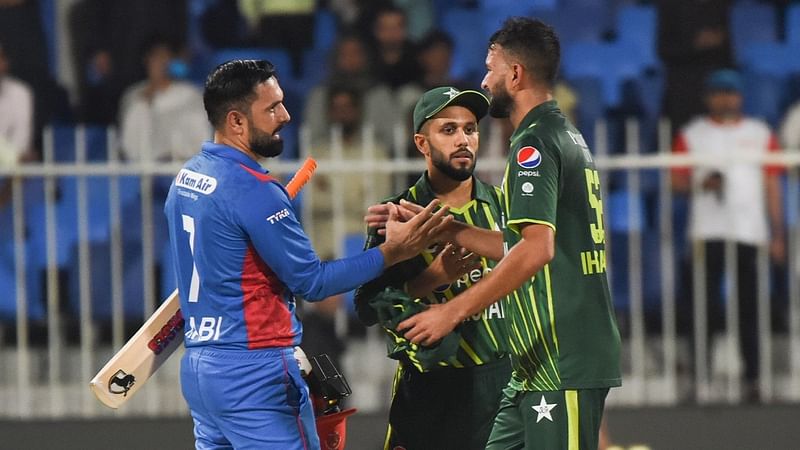 Afghanistan all-rounder Mohammad Nabi shakes hands with Pakistan players after their win over Pakistan in the first T20 at the Sharjah Stadium in the UAE on 24 March 2023