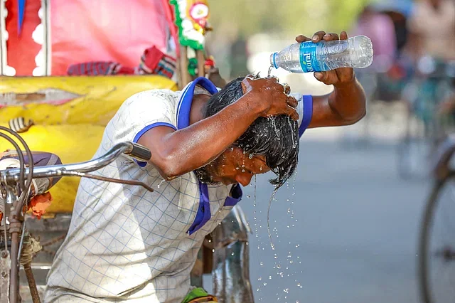 The rickshaw puller has no alternative but to come out into the scorching heat to earn a living. He pours a bottle of water over his head for some relief in the burning sun. Dhaka University, 13 April