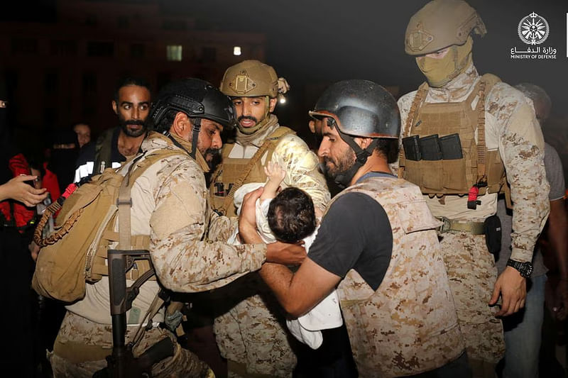 Saudi Royal Navy officers assist a child onboard their navy ship as they evacuate Saudis and other nationals are through Saudi Navy Ship from Sudan to escape the conflicts, Port Sudan, on 22 April, 2023.