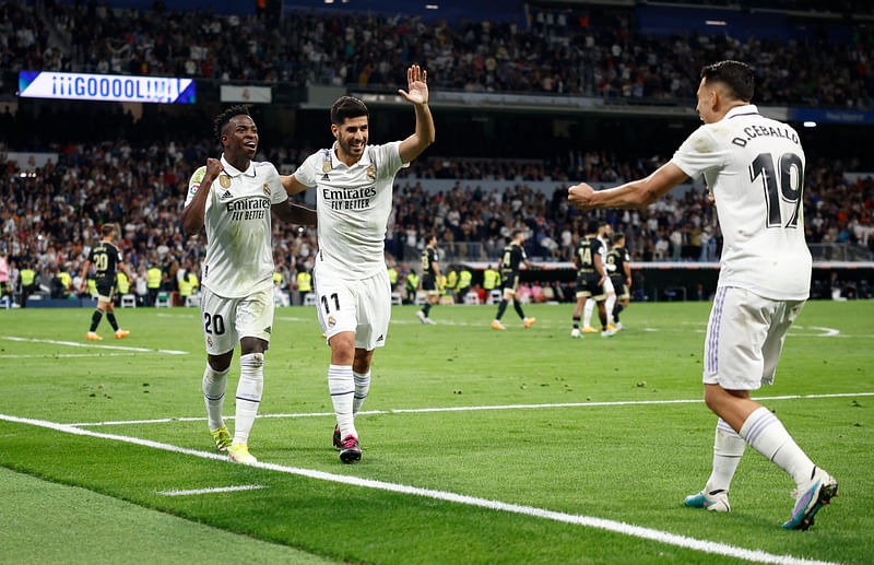 Real Madrid's Marco Asensio celebrates scoring their first goal with Vinicius Junior and Dani Ceballos during the La Liga match against Celta Vigo on 22 April, 2023