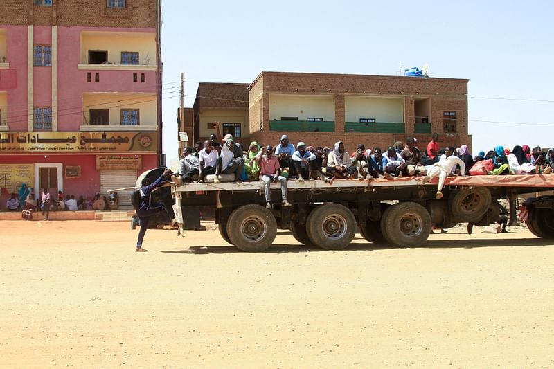 People fleeing street battles between the forces of two rival Sudanese generals, are transported on the back of a truck in the southern part of Khartoum, on 21 April, 2023