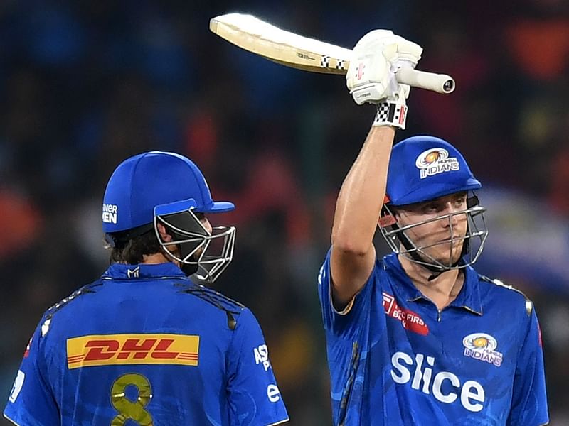 Mumbai Indians' Cameron Green celebrates after scoring a half-centurynext to his teammate Tim David during the Indian Premier League match between Sunrisers Hyderabad and Mumbai Indians at the Rajiv Gandhi International Cricket Stadium in Hyderabad on 18 April 2023