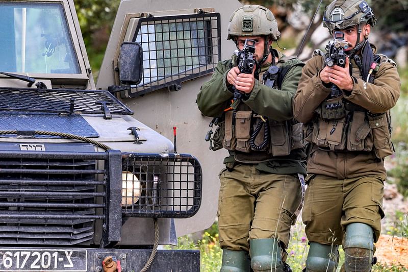 Israeli soldiers sweep an area during an army operation near the settlement of Elon Moreh in the occupied West Bank near Nablus on 11 April 2023