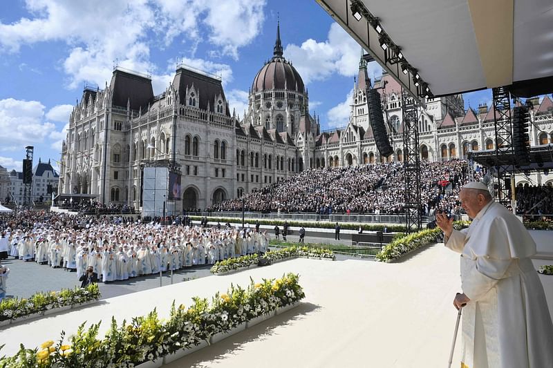 In this handout photo released by the Vatican Media on April 30, 2023 Pope Francis waves as he celebrates a holy mass at Kossuth Lajos' Square during his visit in Budapest, on the last day of his tree-day trip to Hungary