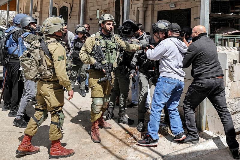 An Israeli soldier intervenes as an Israeli border guard and a Palestinian protester scuffle together during a "Land Day" demonstration in the Palestinian town of Huwara in the occupied West Bank on 31 March, 2023