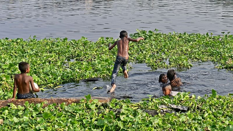 Children take bath in Buriganga river on a hot summer day in Dhaka on 19 April, 2023