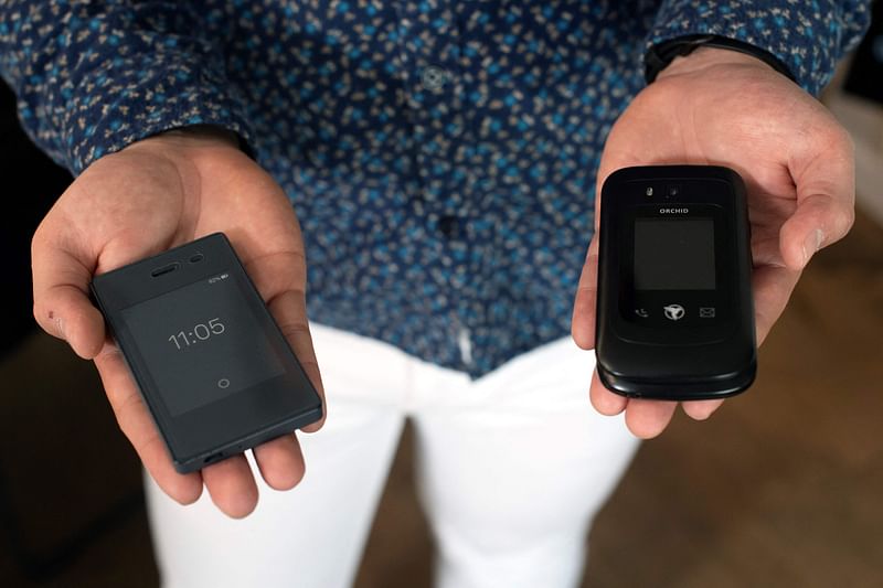 Jose Briones displays his Light Phone 2 (L) and Sunbeam F1 phone at his apartment in Littleton, Colorado, on 24 March, 2023. Briones, 27, decided to stop using a smartphone in 2019, and instead uses what he refers to as a dumbphone, a change he felt was necessary to become more independent and less reliant on technology, resulting in a more simple and happier lifestyle.