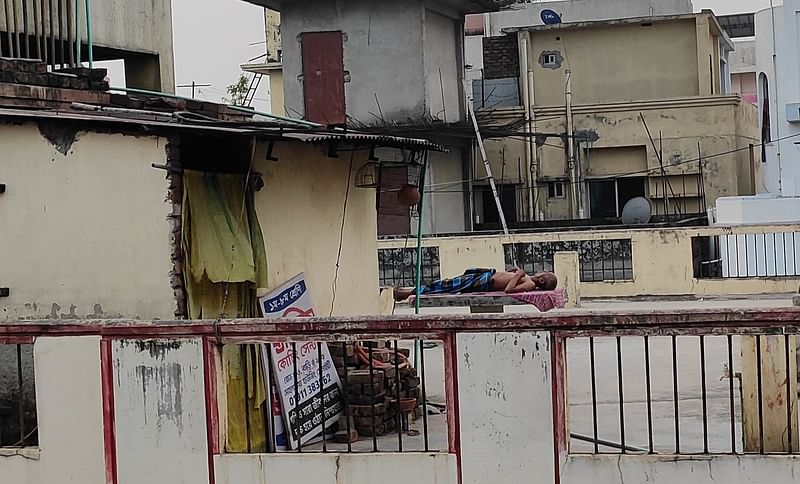 A man sleeping on the rooftop as there was no electricity in A block of Nobodoy Housing for almost seven hours