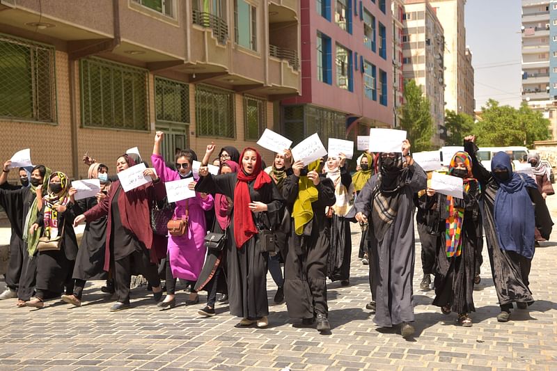 Afghan women hold placards as they march to protest for their rights, in Kabul on 29 April, 2023