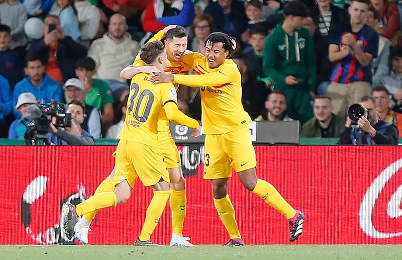 Barcelona's Polish forward Robert Lewandowski celebrates with Spanish midfielder Gavi and French defender Jules Kounde scoring his team's third goal during the La Liga match between Elche CF and FC Barcelona at the Martinez Valero stadium in Elche on 1 April 2023