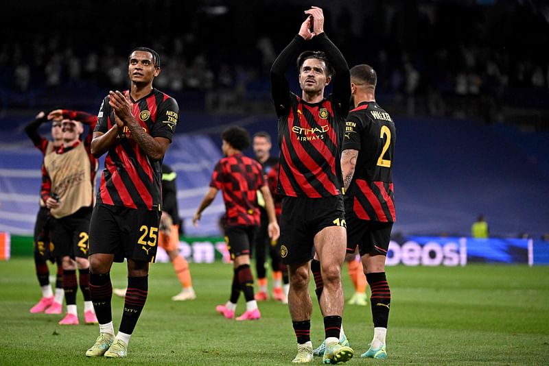 Manchester City's Swiss defender Manuel Akanji and English midfielder Jack Grealish applaud at the end of the UEFA Champions League semi-final first leg match between Real Madrid CF and Manchester City at the Santiago Bernabeu stadium in Madrid on 9 May 2023