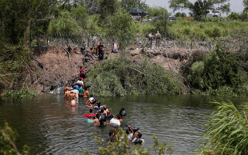 Migrants cross the Rio Bravo river to turn themselves in to U.S. Border Patrol agents before the lifting of Title 42, as seen from Matamoros, Mexico 11 May, 2023