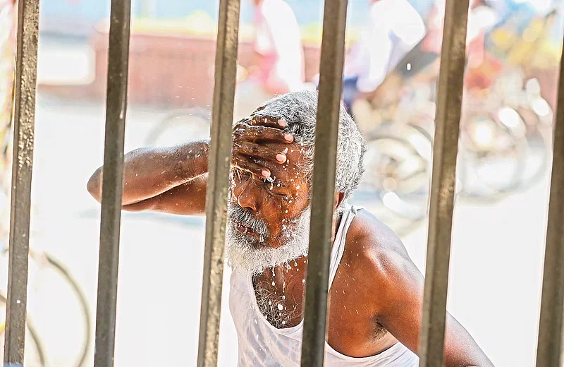 A man washes his face with cold water at the Dhaka University area during the severe heatwave