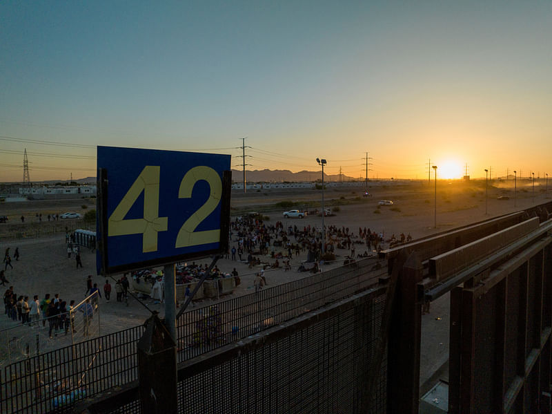 Migrants stand near Border Gate 42 along the border highway, as the U.S. prepares to lift COVID-19 era Title 42 restrictions that have blocked migrants at the border from seeking asylum since 2020, in El Paso, Texas, US, on 11 May
, 2023