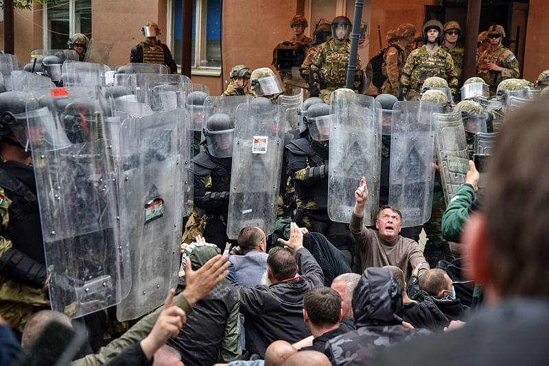 Local Kosovo Serb protesters sit on the ground in front of NATO Kosovo Force (KFOR) soldiers in the town of Zvecan, Kosovo, May 29, 2023