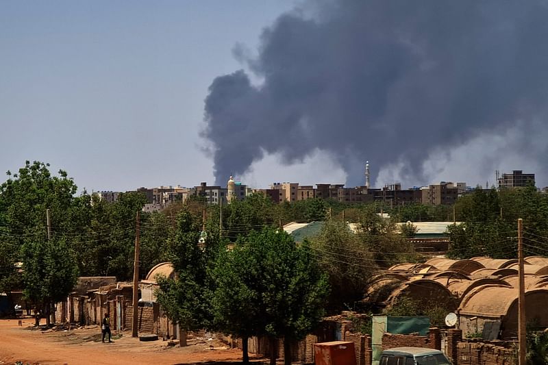 Smoke billows over buildings in Khartoum on 1 May, 2023 as deadly clashes between rival generals' forces have entered their third week.