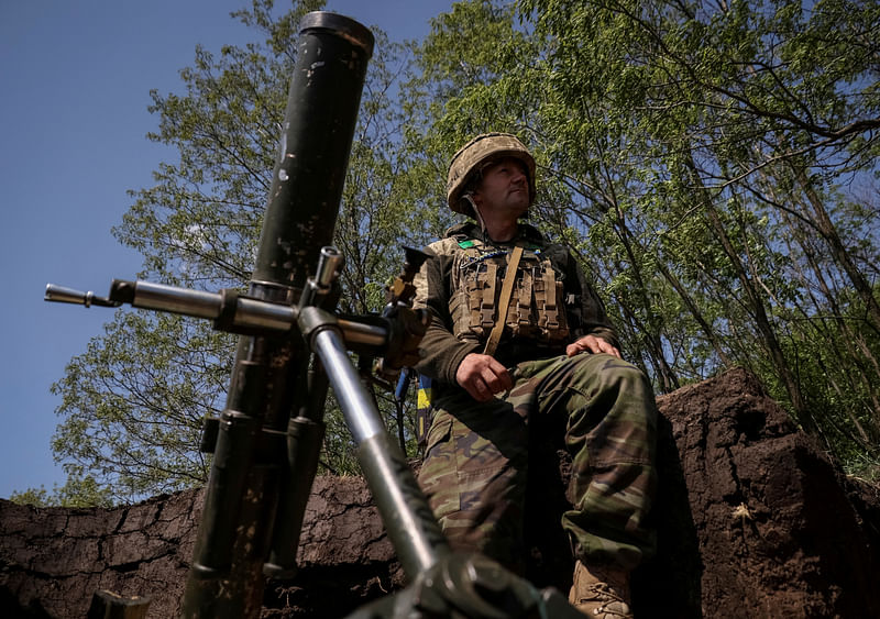 A Ukrainian service member from a 28th separate mechanised brigade named after the Knights of the Winter Campaign of the Armed Forces of Ukraine, prepares to fire a mortar at his positions at a front line, amid Russia's attack on Ukraine, near the city of Bakhmut in Donetsk region, Ukraine on 18 May, 2023