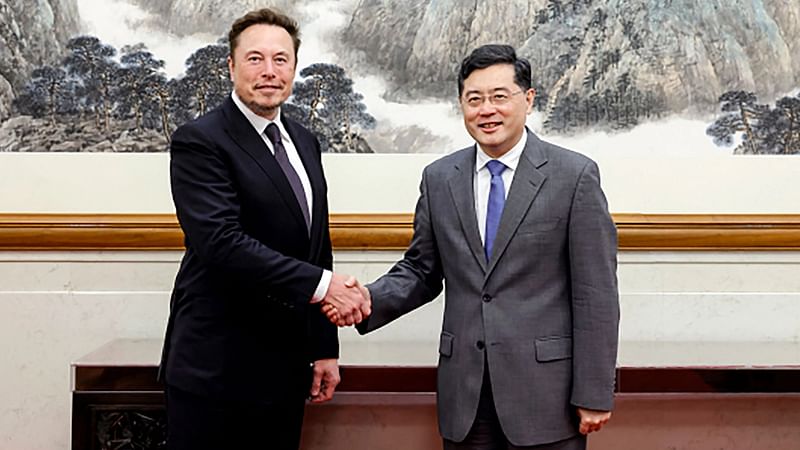 This handout picture taken and released by the Ministry of Foreign Affairs of the People’s Republic of China on 30 May, 2023 shows Tesla CEO Elon Musk (L) shaking hands with China's Foreign Minister Qin Gang during a meeting in Beijing