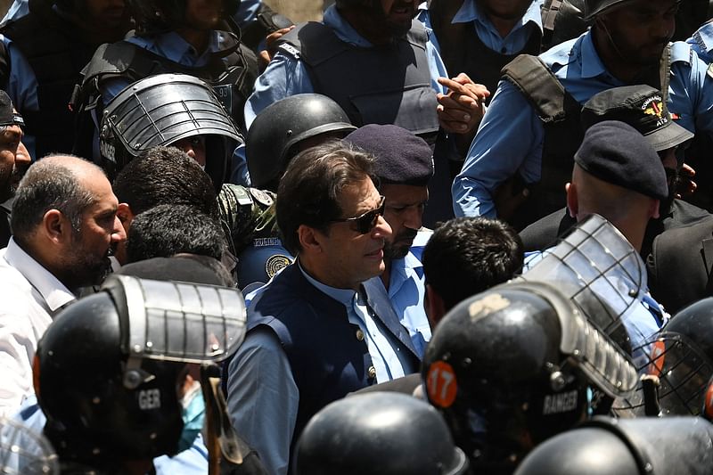 Police cammandos escort former Pakistan's Prime Minister Imran Khan (C) as he arrives at the high court in Islamabad on 12 May, 2023. Former Pakistan prime minister Imran Khan was granted bail by the Islamabad High Court on 12 May, after his arrest on corruption charges this week sparked deadly clashes before being declared illegal.